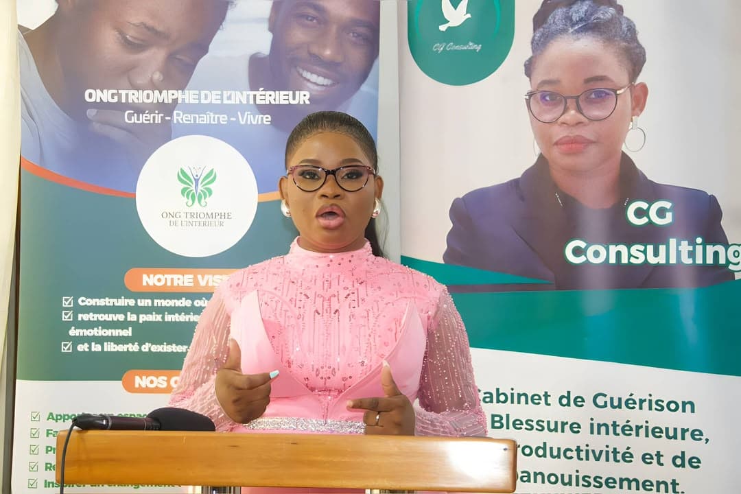 Christelle Eugénie Gnimassou s'exprime au pupitre devant la presse, entourée des bannières de l'ONG Triomphe de l'Intérieur et de CG Consulting