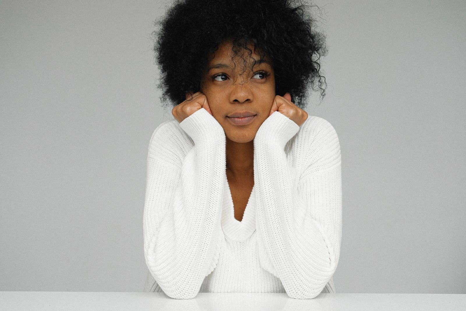 Portrait d'une femme pensive, le visage posé sur ses mains